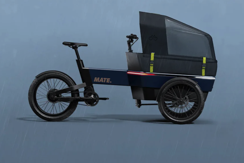 MATE SUV Cargobike Der MATE SUV wurde als perfekte Alternative zum Auto entwickelt, mit der Sie sich problemlos durch die Stadt bewegen und den Verkehr umgehen können. Ob Sie mit Ihren Kindern auf dem täglichen Schulweg, Ihrem Partner oder einem Freund unterwegs sind, auf den MATE SUV können Sie sich im Alltag verlassen. Mit einer Akkuladung legt der MATE SUV bis zu 100 km zurück und bewältigt auch schwere Lasten mit Leichtigkeit. Der starke Mittelmotor mit Tretunterstützung ermöglicht ein müheloses und bequemes Manövrieren. Mit der optionalen Regenschutzhaube müssen Sie auch an Regentagen nicht nach dem Autoschlüssel greifen und können Ihre Waren sicher ausliefern. Der MATE SUV mit seinem modularen Design und einer Reihe von Optionen bietet Ihnen die Freiheit, jede Version von Ihnen zu entdecken. Eine Auswahl an Kasteninterieur, das Allwetterdach, die Geländereifen und die exklusive MATE Wing-Technologie machen ihn zum vielseitigsten SUV auf dem Markt.